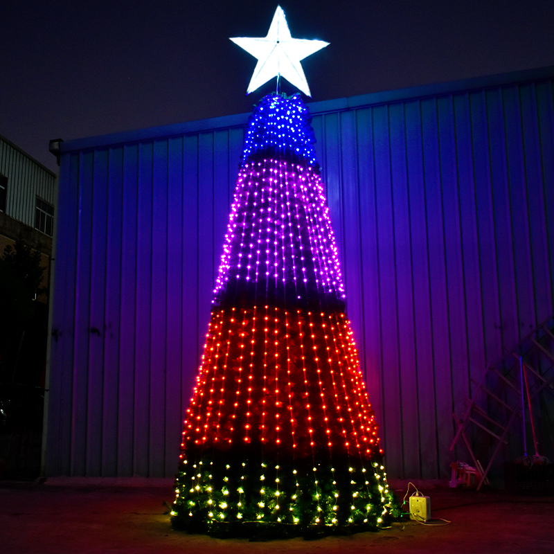 Illuminated cone-shaped Christmas tree with a white star topper in a workshop at night
