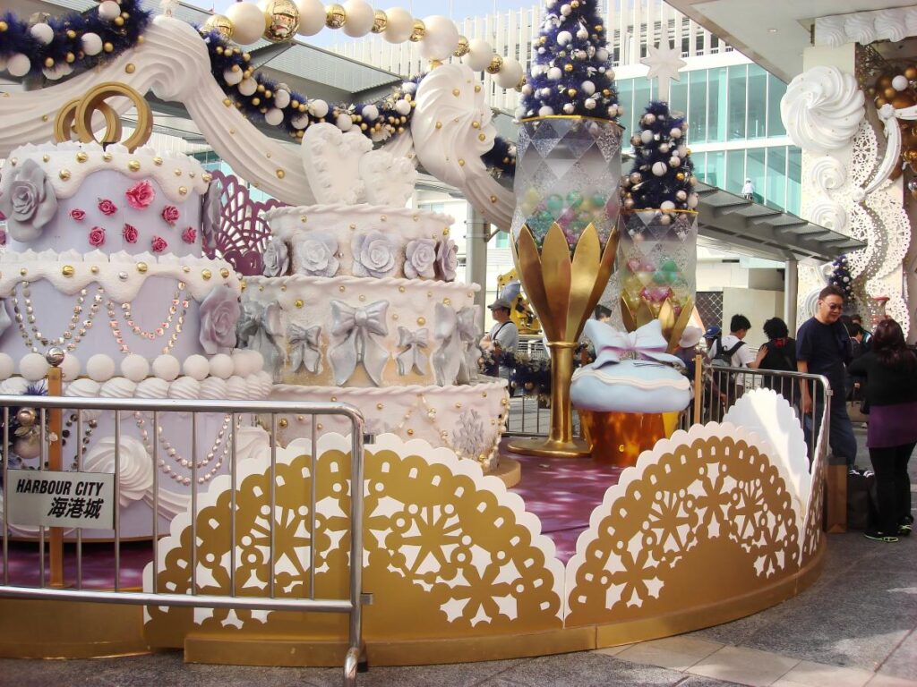 Themed Christmas display in a shopping mall plaza with oversized festive props and photo-friendly holiday decorations