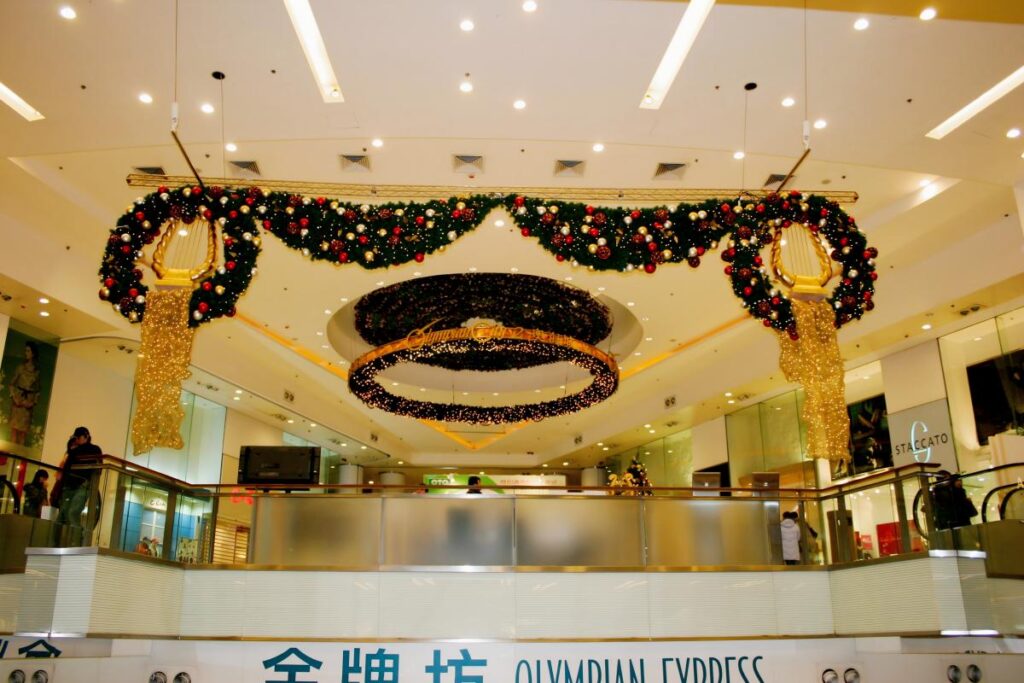 Christmas hanging garland and ceiling wreath decoration in a shopping mall atrium designed to enhance festive atmosphere and visual layering