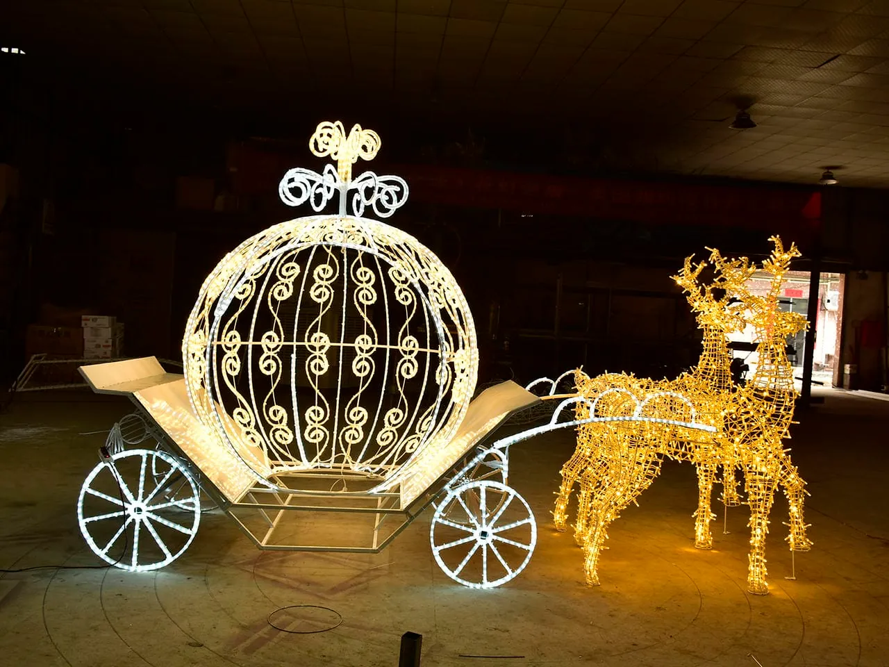 Illuminated carriage and two reindeer frames photographed in a workshop