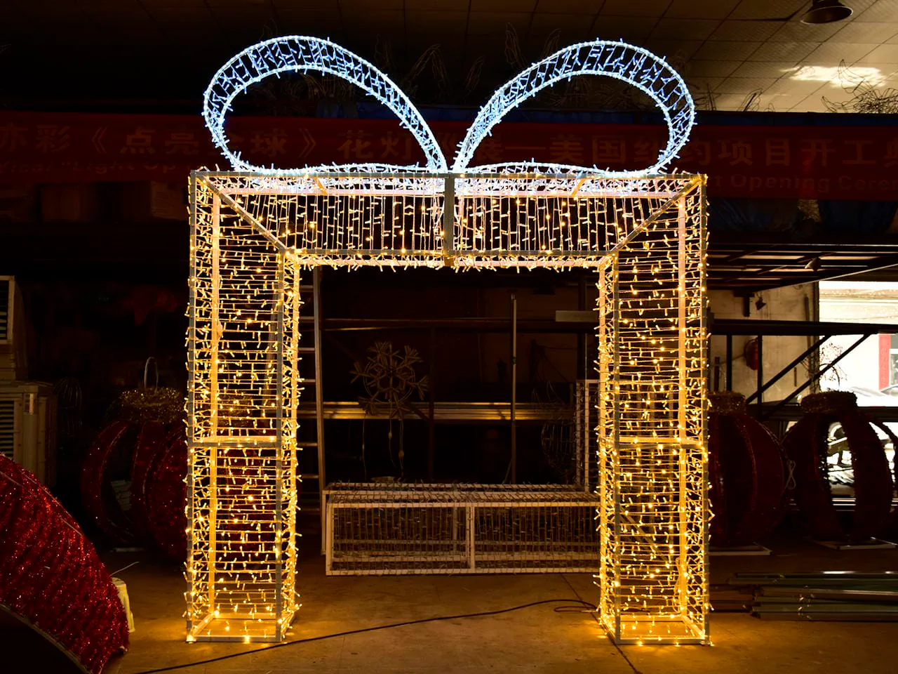 Illuminated gift-box-shaped arch with a rectangular opening photographed in a workshop
