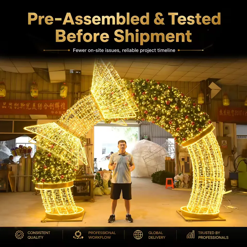 Curved Christmas wreath arch with warm white lights and a gold wireframe bow in a workshop
