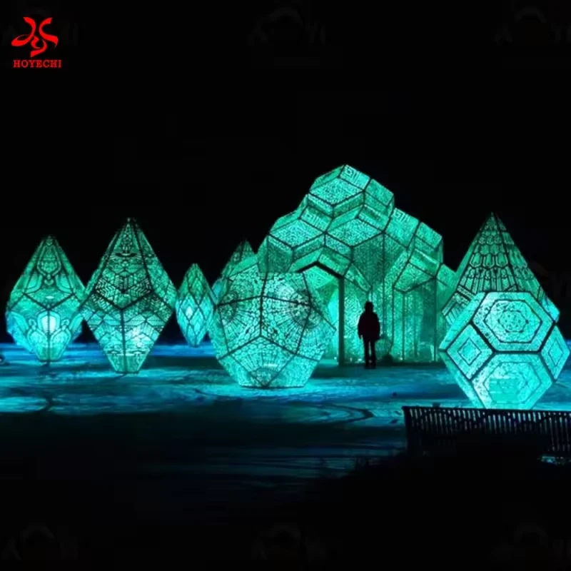 Group of turquoise geometric light sculptures in an outdoor display