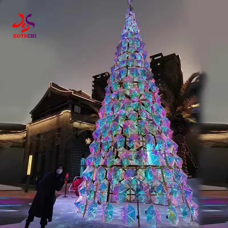 شجرة عيد الميلاد الهندسية المضيئة المعروضة بجانب مبنى تجاري