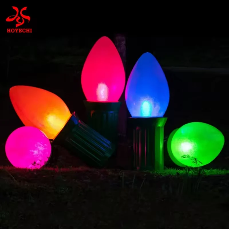Giant Christmas bulbs glowing in red blue orange and green at night