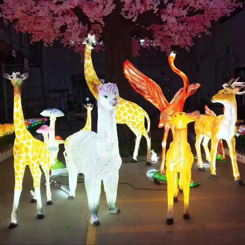 Glowing giraffe with alpaca and deer sculptures in a colorful commercial animal display