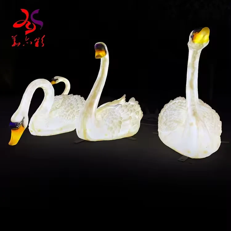Three LED swan sculptures showing raised and curved neck designs