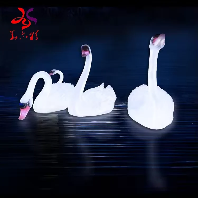 Illuminated white swan sculptures with pink beak accents