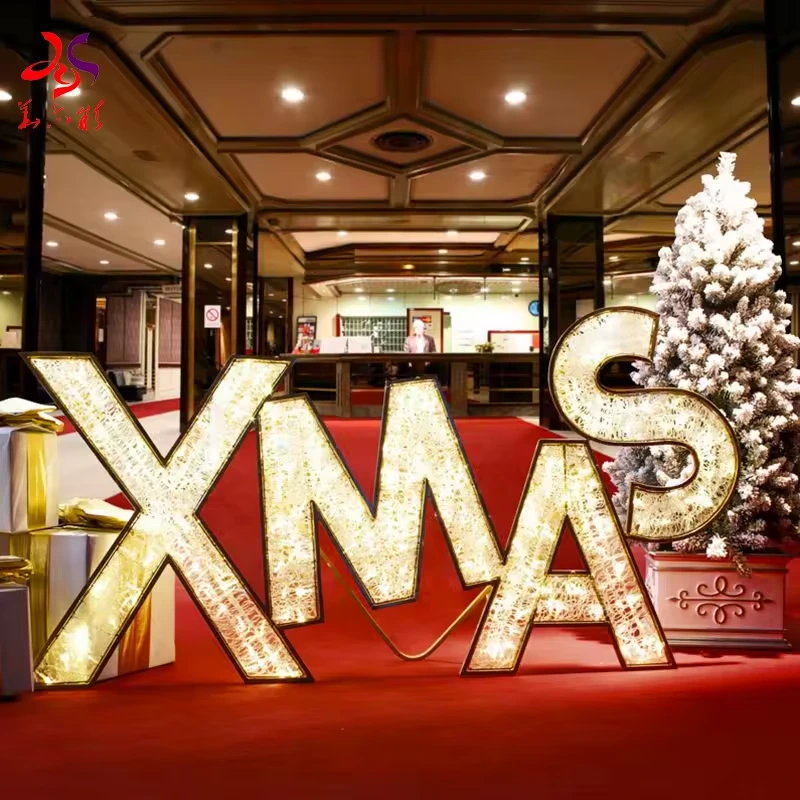 Large illuminated XMAS letters beside an indoor Christmas tree