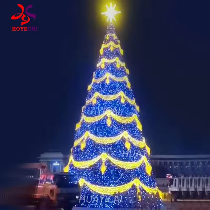 Blue and gold commercial Christmas tree with illuminated scalloped garlands at night