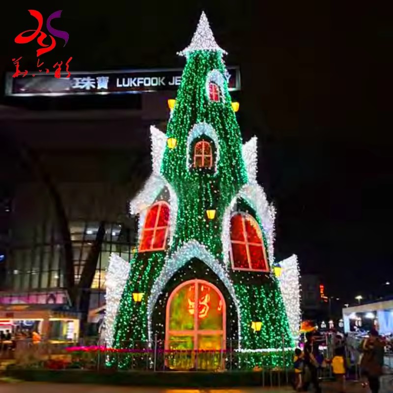 Green castle Christmas tree with illuminated windows and doorway in a commercial plaza