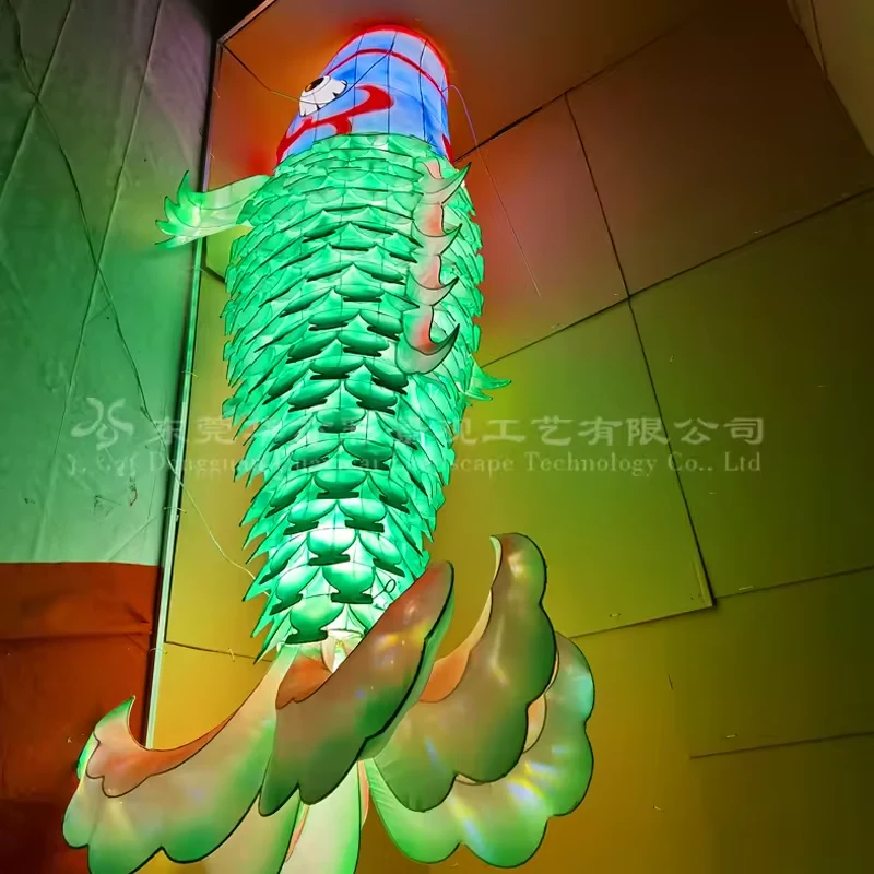 Hanging green fish lantern viewed from below with a wide decorative tail