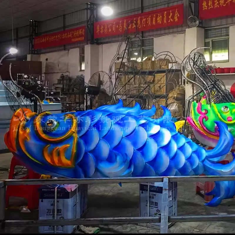 Blue Chinese fish lantern showing its illuminated body and curled tail in the workshop