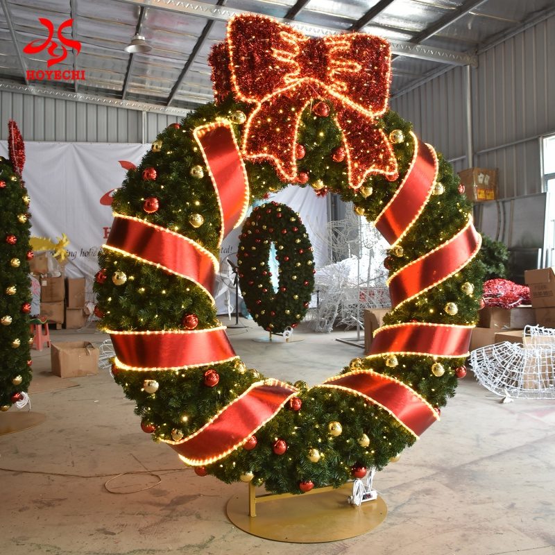 Large outdoor Christmas wreath decoration with LED lights, red ribbon and bow for commercial holiday display