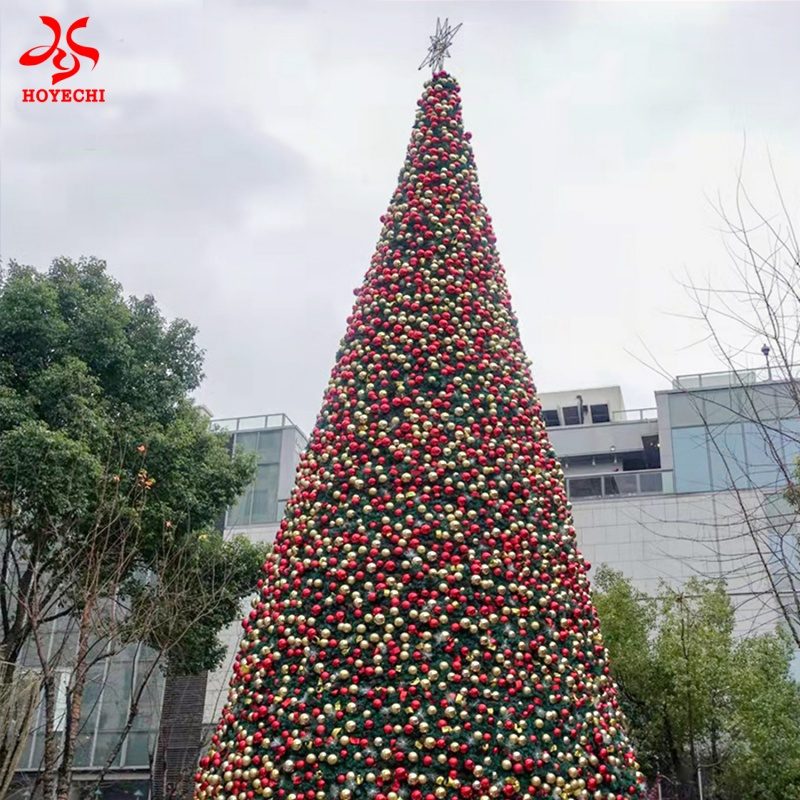 Giant outdoor Christmas tree with dense red and gold ornament balls for commercial holiday display