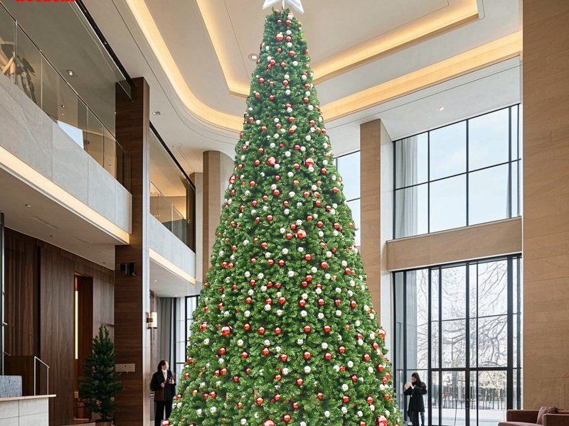 Large commercial Christmas tree displayed in a modern indoor lobby with ornaments and star topper.