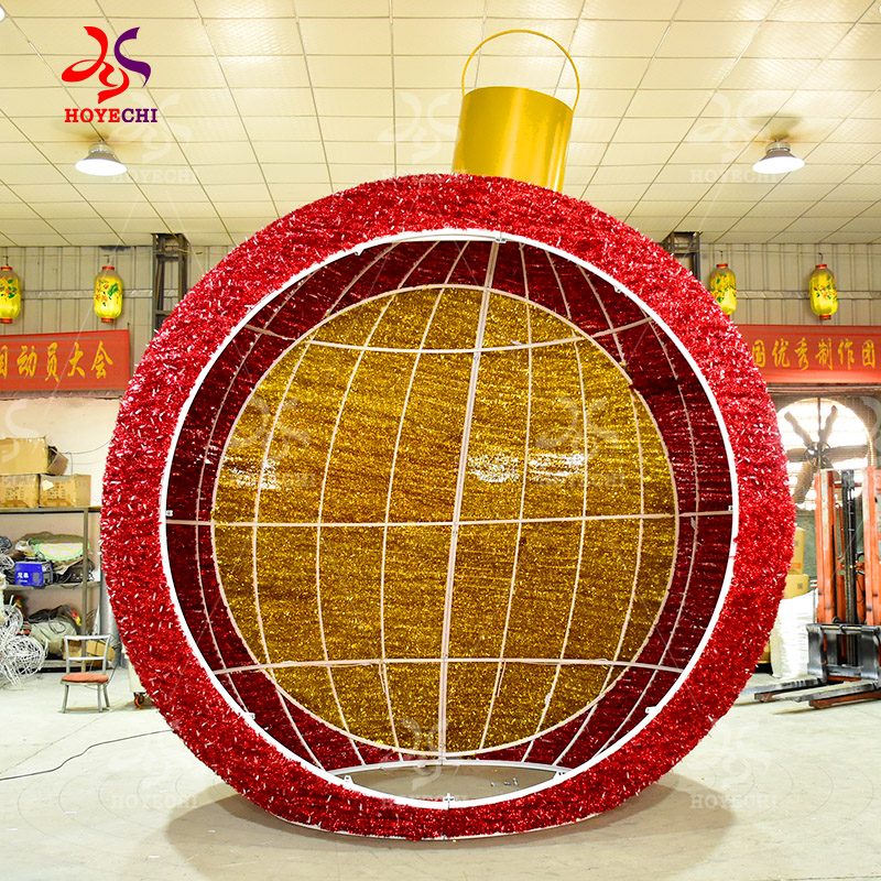 Walk through giant Christmas ornament ball light decoration in red and gold for commercial holiday display