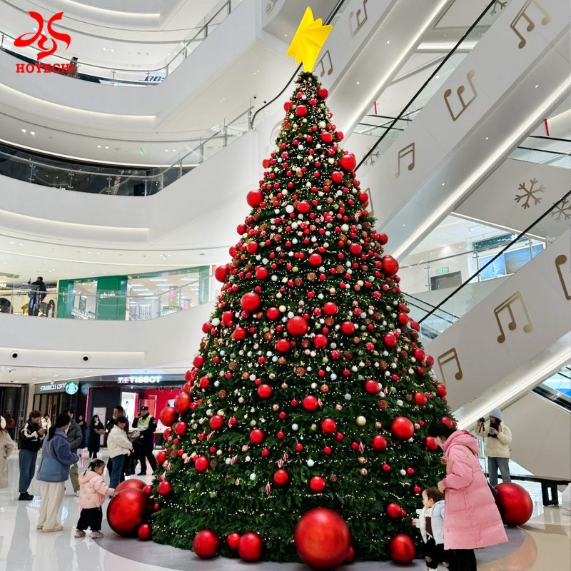 Giant outdoor Christmas tree with dense red and gold ornament balls for commercial holiday display