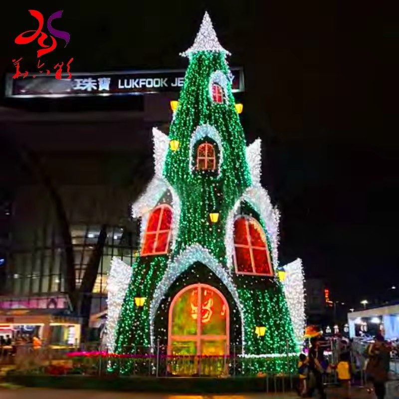Green castle Christmas tree with illuminated windows and doorway in a commercial plaza