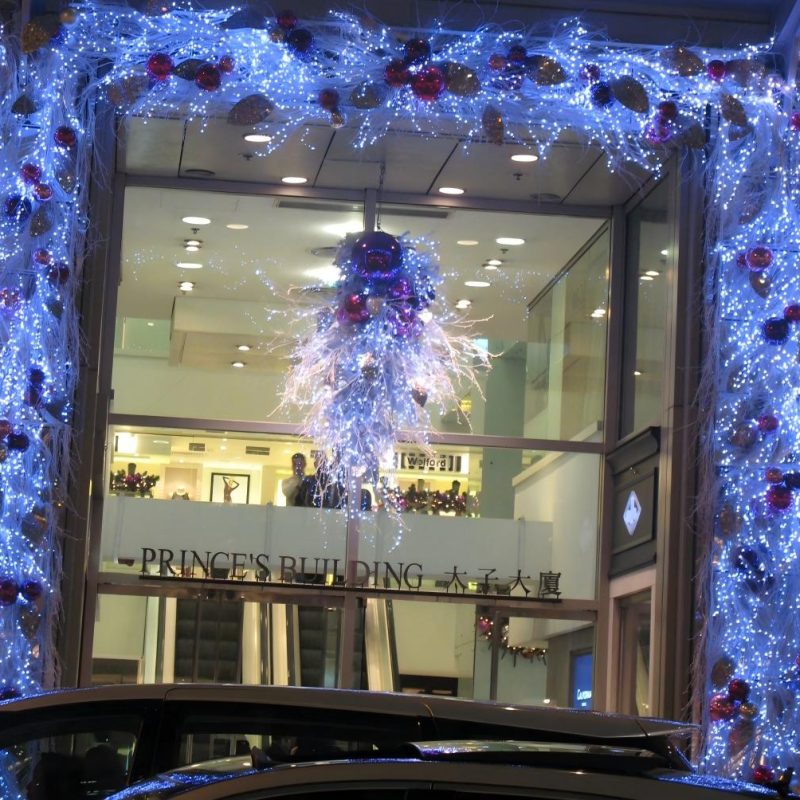 Entrada de edifício comercial com guirlanda de Natal, decoração de moldura iluminada e peça central festiva suspensa