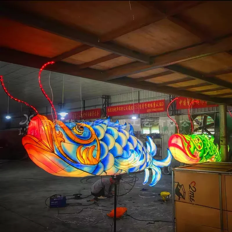 Illuminated blue and gold hanging fish lantern with long whiskers in the HOYECHI workshop
