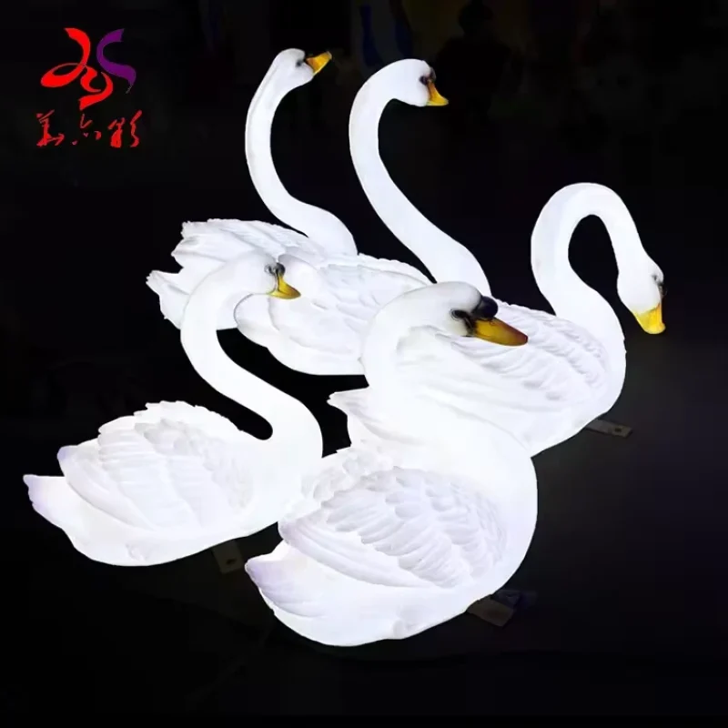 Group of white illuminated fiberglass swan sculptures in different poses