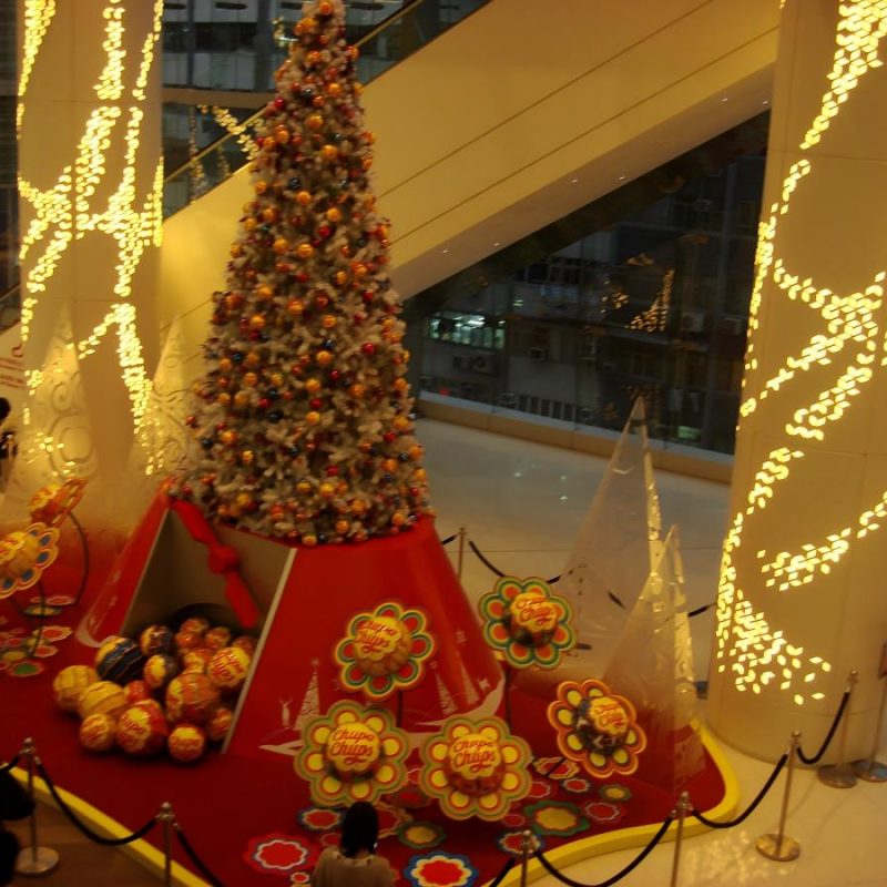 Exposição de Natal no átrio de um centro comercial com uma árvore decorada, adereços festivos temáticos e um cenário de férias propício à fotografia